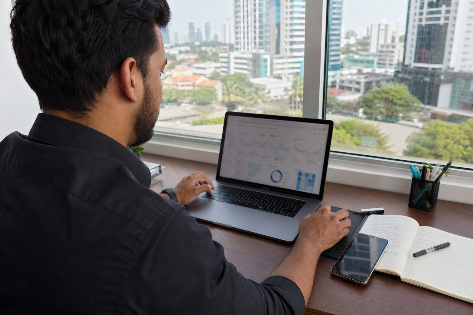 Especialista panameño analiza métricas de posicionamiento SEO desde una laptop junto a una ventana de Ciudad de Panamá