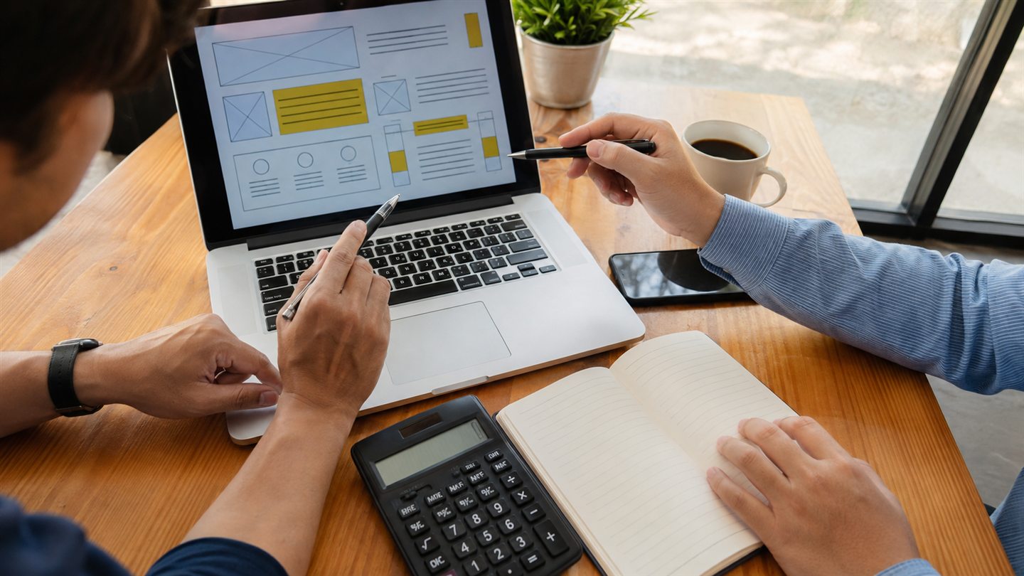 Emprendedora en Panamá revisando en su celular una cotización de diseño web junto a una laptop